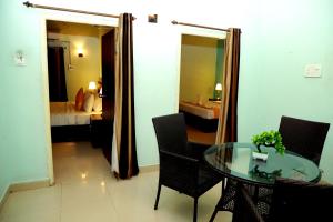 a room with a glass table and a bedroom at Ananya Eco Resort in Surūrnagar