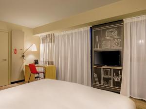 a hotel room with a bed and a television at ibis Tbilisi Stadium in Tbilisi City