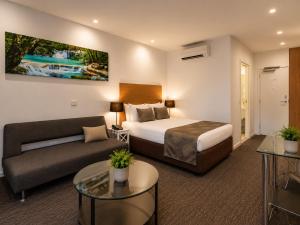 a hotel room with a bed and a couch at Belmercer Motel in Geelong +34 photos