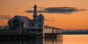 a large building on the water with a lighthouse at Belmercer Motel in Geelong