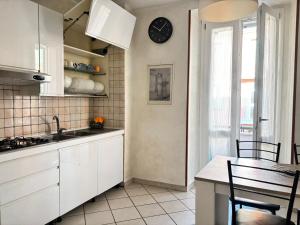 a kitchen with white cabinets and a clock on the wall at Pasubio House appartamento in Campobasso