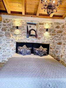 a bedroom with a bed in a stone wall at Studio apartmani Šverko in Punat