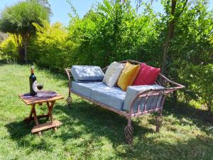 a bench with pillows on it sitting in the grass at Sereni stays in Nakuru