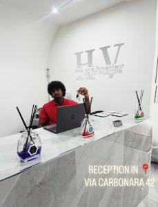 a man sitting at a table with a laptop at HV Carbonara 123 in Naples