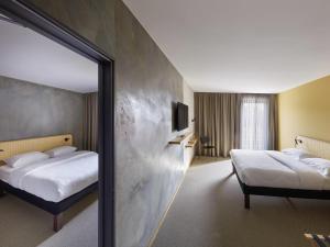 a hotel room with two beds and a mirror at ibis Styles Bayreuth in Bayreuth +58 photos