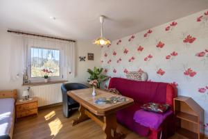 a living room with a purple couch and a table at Zum Hecht in Herrnhut