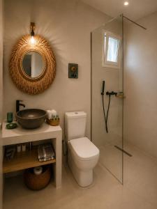 a bathroom with a toilet and a sink and a mirror at Diana's Luxury Suites in Kithnos +53 photos