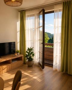 a living room with a television and a sliding glass door at Apartmán PERLA 28 Říčky v Orlických horách in Říčky