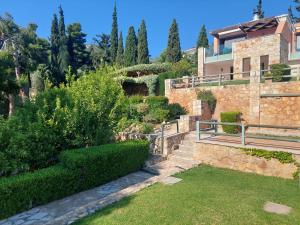 a house with a garden in front of it at Villa Lemóni - Villa by the sea with swimming pool and amazing view in Xiropigado