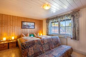 a bedroom with a bed and a couch and a window at Zum Hecht in Herrnhut