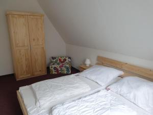 a bedroom with two beds and a wooden cabinet at Sauberghaus Wohnung 1 in Breitenbrunn +15 photos