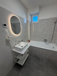 a bathroom with a sink and a tub and a mirror at Ady80 in Balatonmáriafürdő +12 photos