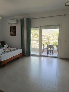 a bedroom with a bed and a sliding glass door at Athina Rooms in Himare