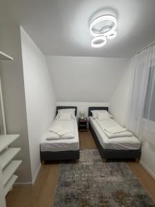 a room with two beds and a window with a rug at Ady80 in Balatonmáriafürdő