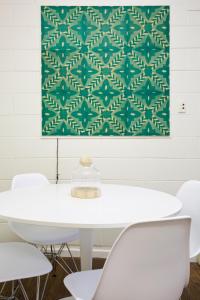 a table with white chairs and a green tapestry at The Old Mount Gambier Gaol in Mount Gambier