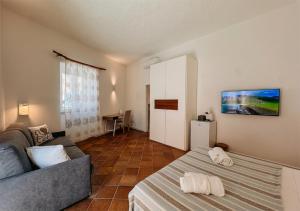 a living room with a bed and a couch at Isuleddu Room & Stairs in La Maddalena