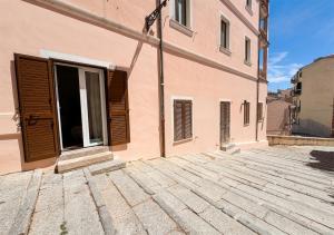 a building with a door on the side of it at Isuleddu Room & Stairs in La Maddalena
