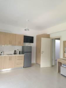 a kitchen with wooden cabinets and a refrigerator at Athina Rooms in Himare +48 photos
