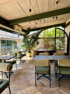 a restaurant with tables and chairs and windows at L'Imprevisto in Grasse