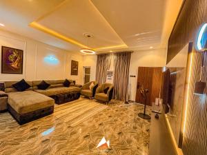 a large living room with a couch and a tv at Hols in Kaduna