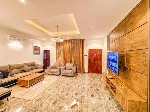 a living room with a couch and a flat screen tv at Hols in Kaduna