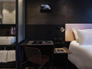 a bedroom with a bed and a desk and a sink at TRIBE Paris Batignolles in Paris