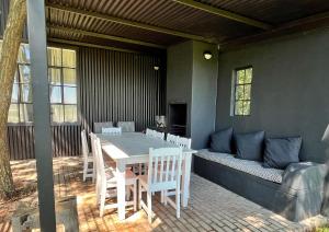 a patio with a table and chairs and a couch at Field Cabin in Rosendal +5 photos