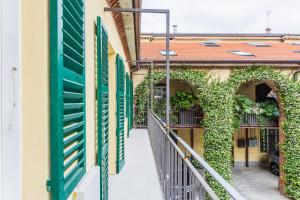 an alleyway between two buildings with green shutters at Civico Due in Cuneo
