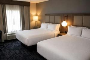 a hotel room with two beds and a window at City Express by Marriott Lafayette in Lafayette