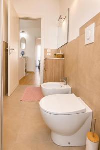 a bathroom with a white toilet and a sink at Zia Piera in Follonica +12 photos