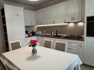 a kitchen with a table with a vase of flowers on it at Casa Carolina in Alba Iulia