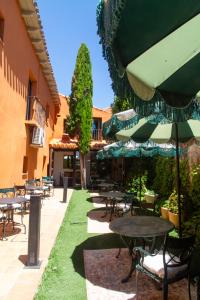 a patio with tables and chairs and an umbrella at Maison Conde de la Cebada in Ampudia