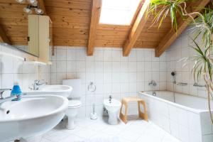 a bathroom with two sinks and a tub and a toilet at Allgäu Holzhaus I Bergpanorama & Natur pur im Herzen des Allgäus! in Weitnau +99 photos