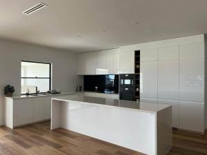 a large kitchen with white cabinets and a counter top at Moonta Bay Hideaway in Port Moonta