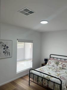 a bedroom with a bed and a window at Moonta Bay Hideaway in Port Moonta