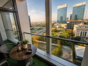 a balcony with a table and chairs and a view of a city at AsiaWay Apartment-NEST ONE in Tashkent