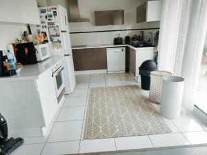 a kitchen with white appliances and a white tiled floor at La Petite Maison dans la Prairie in Cholet +5 photos