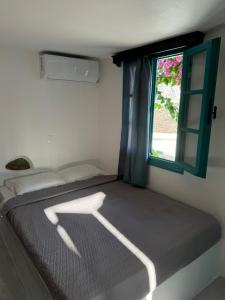 a bed in a room with a window at Kamares in Tholária