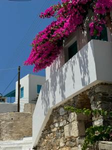 a building with purple flowers on the side of it at Kamares in Tholária