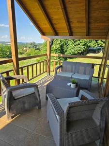 a patio with wicker chairs and tables on a deck at LIPA houses & spa in Sopot