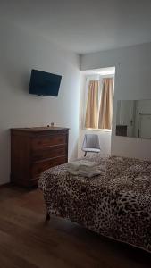 a bedroom with a leopard print bed and a dresser at B&B Yle in Cetraro