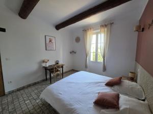 a bedroom with a large white bed and a table at Mas de la Bimarde in Monteux