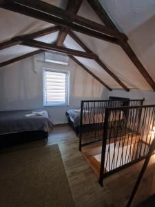 a attic room with two beds and a window at Vacation Home Belluna in Račić +46 photos