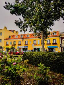 a yellow building with a tree in front of it at Sea Garden Peniche in Peniche