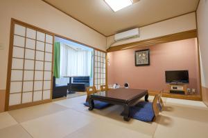 a living room with a table and chairs and a television at hotel VERDE in Arao