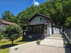 a house with a balcony and stairs in a yard at Vacation Home Belluna in Račić