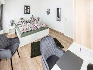 a bedroom with a bed and two chairs at FeWo Seidenglanz in Dillenburg