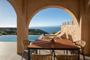 a dining room with a table and chairs on a patio at Ionian Horizon Villas in Tsoukalades