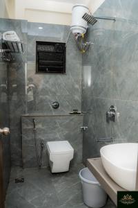 a bathroom with a shower and a toilet and a sink at Sweekar Executive in Tuljapur