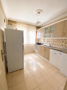 a kitchen with a white refrigerator and a tile floor at Blue61 Residence Airport in Pelitli